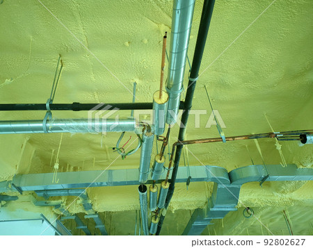 SELANGOR, MALAYSIA - JUNE 8, 2022: A concrete ceiling surface that has been sprayed with a layer of polyurethane foam. The below of PU layer has m&e services such as air conditioning. 92802627