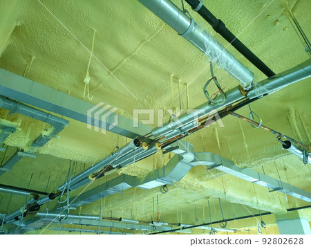SELANGOR, MALAYSIA - JUNE 8, 2022: A concrete ceiling surface that has been sprayed with a layer of polyurethane foam. The below of PU layer has m&e services such as air conditioning. 92802628