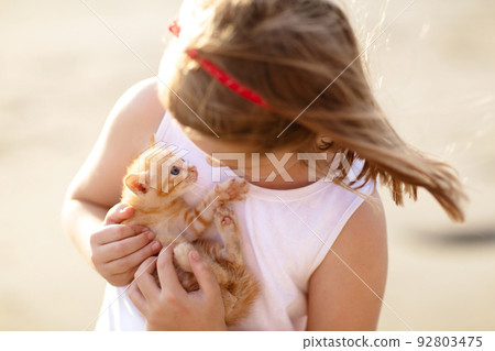 Little girl holding baby cat. Kids and pets 92803475
