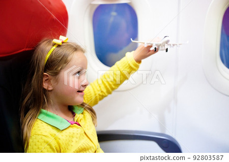 Child flying in airplane. Flight with kids. 92803587