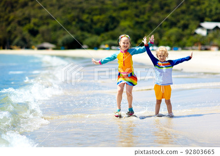 Kids on tropical beach. Children playing at sea. 92803665