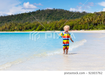 Kids play on tropical beach. Sand and water toy. 92803762