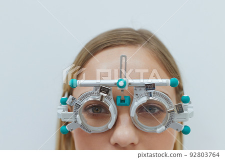 Eyesight Test. Woman In Optometrist Trial Frame At Studio Eyesight Test. Woman In Optometrist Trial Frame At Studio 92803764