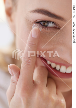 Contact Eye Lens. Smiling Woman Applying Eye Contacts on her Eyes Contact Eye Lens. Smiling Woman Applying Eye Contacts on her Eyes 92803909