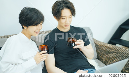 Young couple looking at a laptop in the living room Young couple looking at a laptop in the living room 92803915