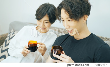 Young couple looking at a laptop in the living room Young couple looking at a laptop in the living room 92803916