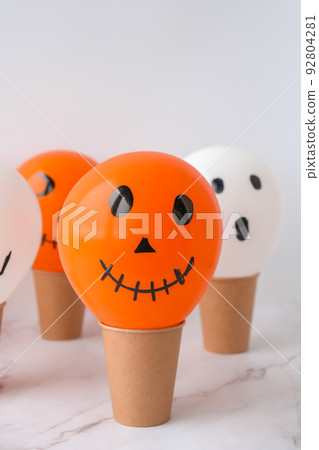 Painted Jacks face on balloons. Orange and white balls preparation diy for halloween party. Halloween home activities. Handmade toys 92804281