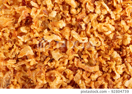 Roasted onions background. Crispy fried onions. Top view. Roasted onions background. Crispy fried onions. Top view. 92804739