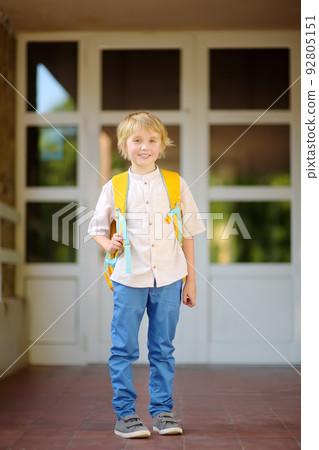 Little student with a backpack at the door of school building. Back to school concept. Little student with a backpack at the door of school building. Back to school concept. 92805151
