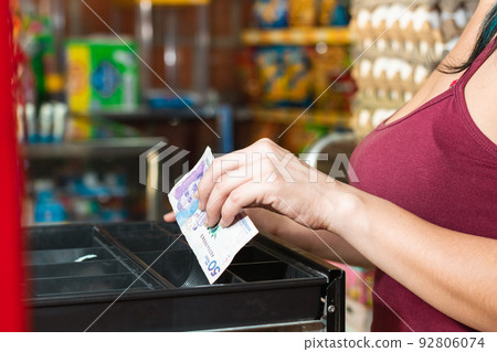 latina woman hand in red blouse opening cash register. taking out money after making a sale, girl working in colombian neighborhood store. entrepreneurship concept. latina woman hand in red blouse opening cash register. taking out money after making a sale, girl working in colombian neighborhood store. entrepreneurship concept. 92806074