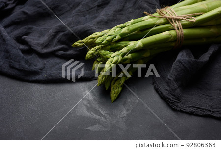 Fresh green asparagus sprouts on a wooden background. View from above Fresh green asparagus sprouts on a wooden background. View from above 92806363