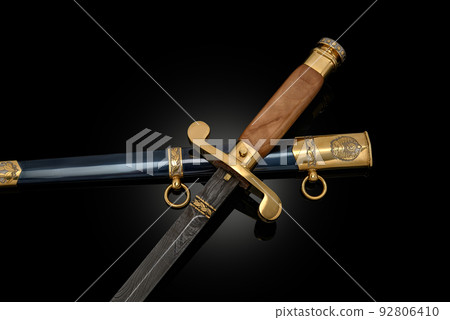 souvenir collectible silver gold dagger cutlass with scabbard, with metal engraving, on black background. Luxury weapons with traditional patterns in medieval vintage style. souvenir collectible silver gold dagger cutlass with scabbard, with metal engraving, on black background. Luxury weapons with traditional patterns in medieval vintage style. 92806410
