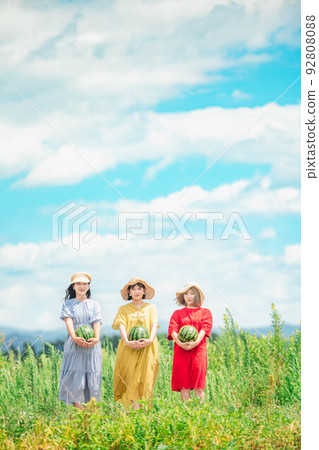 Under the blue sky, three women wearing dresses are photographed holding a watermelon Under the blue sky, three women wearing dresses are photographed holding a watermelon 92808088