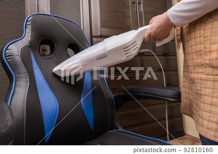 [Middle housewife cleaning the gaming chair with a handy cleaner] 92810160