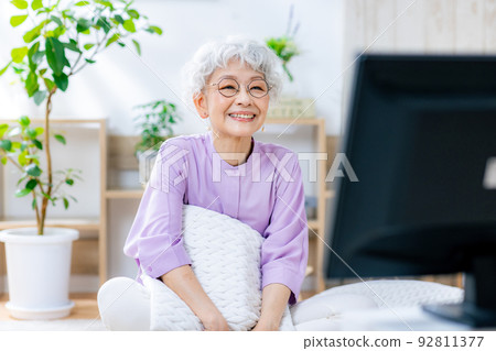 Senior woman watching TV with a smile 92811377