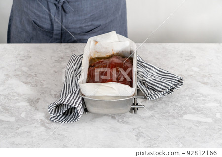 Cooling classic meatloaf glazed with sweet glaze in a loaf pan lined with parchment paper. Cooling classic meatloaf glazed with sweet glaze in a loaf pan lined with parchment paper. 92812166