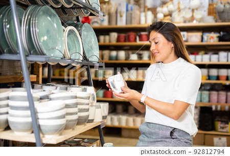 Latino american woman buying ceramic tableware in dishes shop Latino american woman buying ceramic tableware in dishes shop 92812794