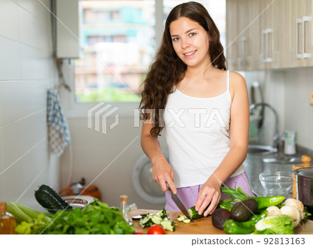 Portrait of woman making fresh vegetable salad Portrait of woman making fresh vegetable salad 92813163