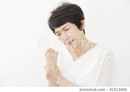 Senior woman with wrist pain White background 92813600
