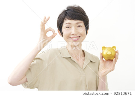 拿著存錢罐和做OK手勢白色背景的資深婦女 92813671