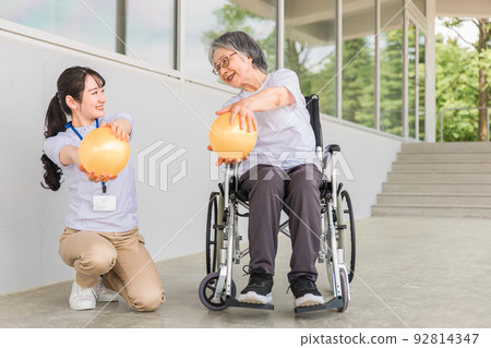 Elderly woman and physiotherapist training muscles 92814347