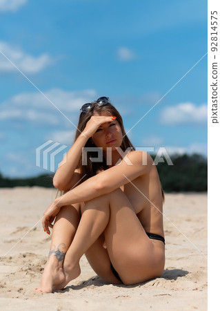 Sensual topless woman on seashore 92814575