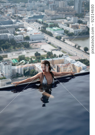 Woman in swimming pool on roof Woman in swimming pool on roof 92814680