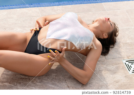 Sensual woman lying near swimming pool Sensual woman lying near swimming pool 92814739