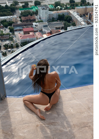 Anonymous seductive woman at poolside on roof 92814741