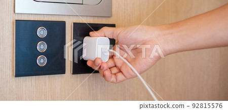Closeup finger unplugging or plugging of electricity device at home. Energy Saving, power, electrical and lifestyle concepts Closeup finger unplugging or plugging of electricity device at home. Energy Saving, power, electrical and lifestyle concepts 92815576