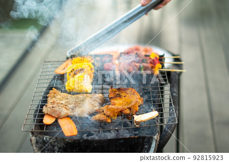 delicious grilled meat with smoke, BBQ with vegetables in outdoor. Barbecue, Party, lifestyle and picnic concept delicious grilled meat with smoke, BBQ with vegetables in outdoor. Barbecue, Party, lifestyle and picnic concept 92815923