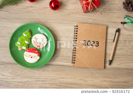 2023 notebook, black, Christmas cookies and pen on wood table, Top view and copy space. Xmas, Happy New Year, Goals, Resolution, To do list, Strategy and Plan concept 2023 notebook, black, Christmas cookies and pen on wood table, Top view and copy space. Xmas, Happy New Year, Goals, Resolution, To do list, Strategy and Plan concept 92816172
