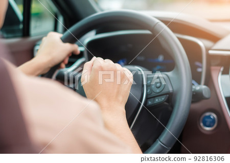 woman driver honking a car during driving on traffic road, hand controlling steering wheel in vehicle. Journey, trip and safety Transportation concepts 92816306