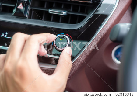 man hand adjusting temperature the air flowing during driving car on the road, air conditioner cooling system inside the car. Adjust, temperature and transport concept 92816315