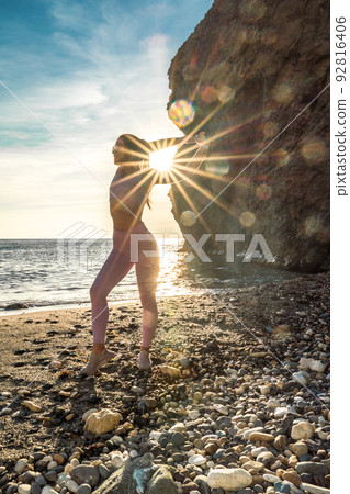 Girl gymnast is training on the beach by the sea sunset. Does twine. Photo series. Girl gymnast is training on the beach by the sea sunset. Does twine. Photo series. 92816406
