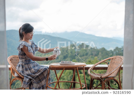 woman drinking tea and looking mountain view, young blogger stay at countryside homestay in the morning.Travel, vacation, journey, trip and relaxing concept woman drinking tea and looking mountain view, young blogger stay at countryside homestay in the morning.Travel, vacation, journey, trip and relaxing concept 92816590
