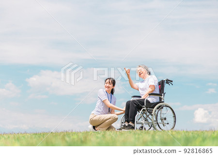 在公園散步的護理人員和坐在輪椅上的老年婦女（外出護理） 92816865