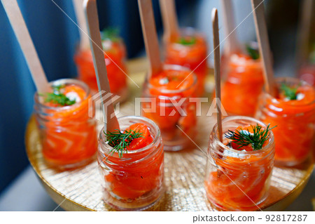 small glass jars with red salted fish. catering services for the party. small glass jars with red salted fish. catering services for the party. 92817287