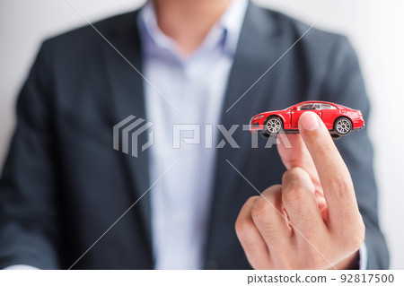 Businessman hand holding red car toy. Car insurance, warranty, rental, Financial, new and repair concept Businessman hand holding red car toy. Car insurance, warranty, rental, Financial, new and repair concept 92817500