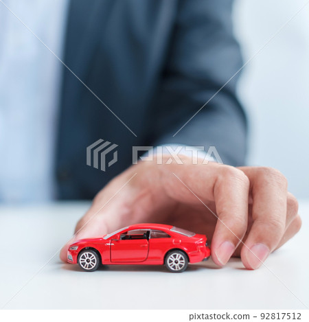 businessman hand holding red car toy. Car insurance, warranty, rental, Financial, new and repair concept businessman hand holding red car toy. Car insurance, warranty, rental, Financial, new and repair concept 92817512