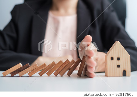 Businessman stop falling wooden blocks and protect house model. Crisis, fall Business, Risk, Economic recession, Developer, Real Estate and Property concept Businessman stop falling wooden blocks and protect house model. Crisis, fall Business, Risk, Economic recession, Developer, Real Estate and Property concept 92817603