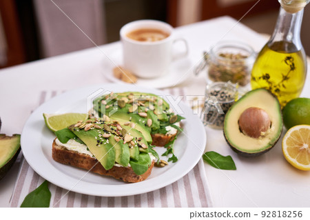 Freshly made Avocado and cream cheese toasts on a white ceramic plate and ingredients 92818256