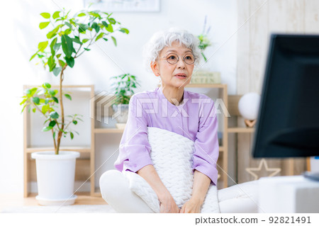 Senior woman thinking while watching TV 92821491