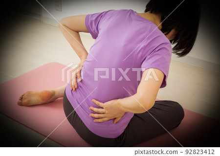 Middle women suffering from low back pain 92823412
