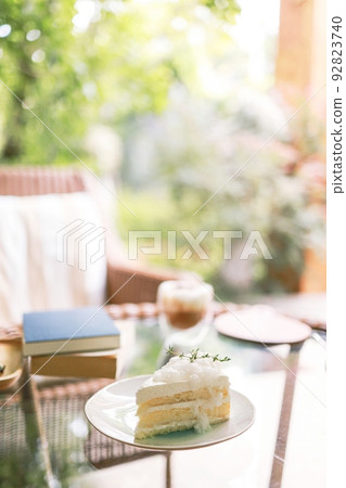 Coconut Cake and Coffee in a cafe on the blur background. traditional dessert Sliced of delicious coconut layer cake Coconut Cake and Coffee in a cafe on the blur background. traditional dessert Sliced of delicious coconut layer cake 92823740