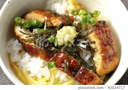 A bird's-eye view of eel dashi chazuke with green onions, chopped seaweed, and wasabi 92824717