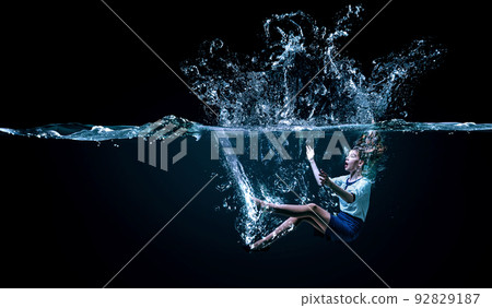 Young businesswoman swimming underwater . Mixed media 92829187