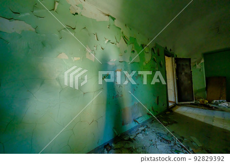 Opened door and crumbling walls in corridor 92829392