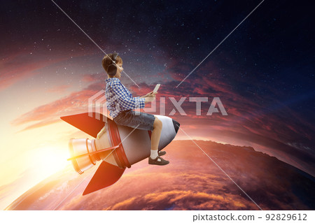 Kid wearing headphones on a rocket 92829612