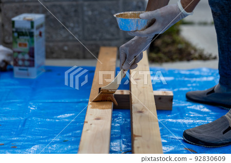 Do-it-yourself man painting pergola pillars 92830609